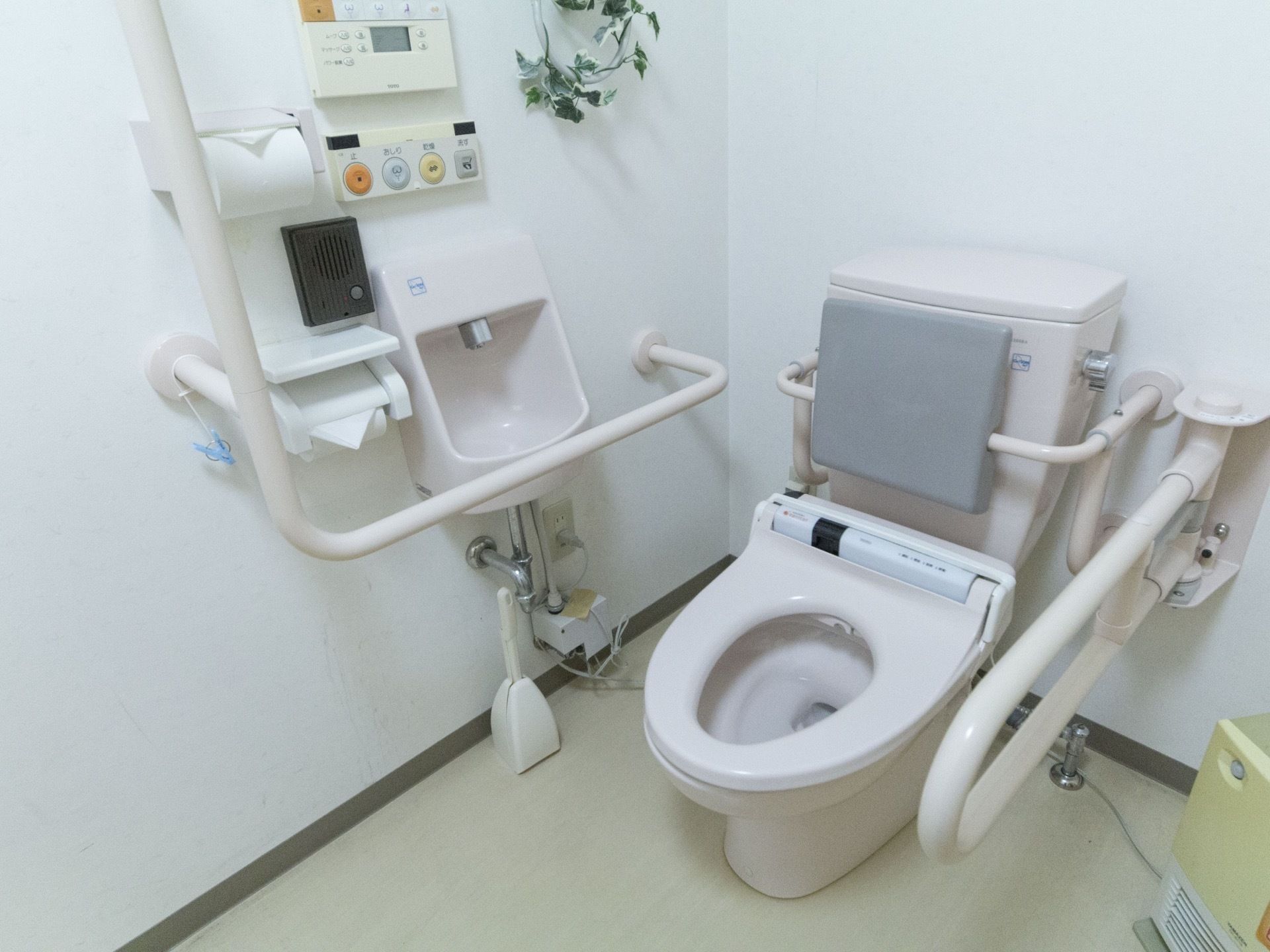 トイレには温水洗浄便座を完備している。手すりと背もたれパッドが設置され足元が冷えないようにヒーターが置かれている。