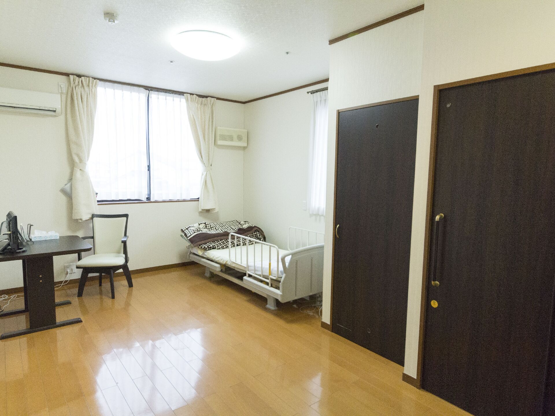 左壁面に2枚のドアがあり、その奥にガード付きのベッドが置かれた居室