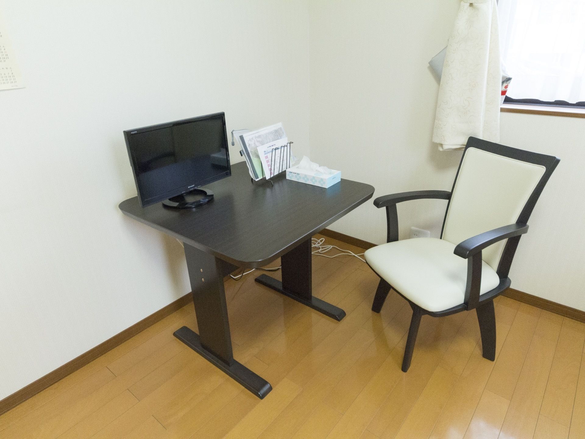 居室には木製のテーブルを配置し、上部に液晶テレビを設置している。椅子はゆったりとした作りで安定性が良い。