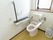 トイレは温水洗浄便座付きで、操作パネルは壁に設置している。すぐ近くに手すりとナースコールを取り付けている