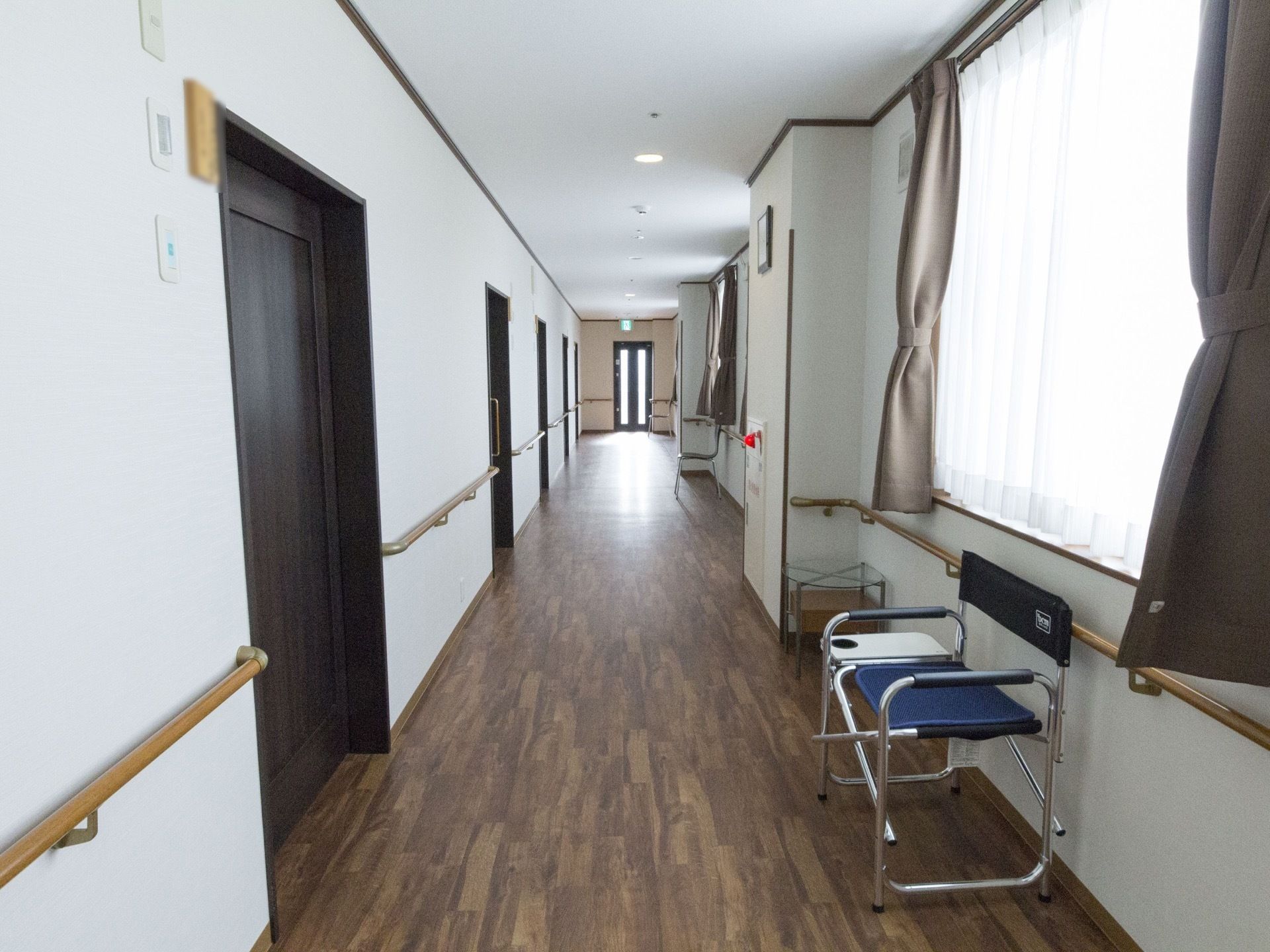 通路に椅子が設置されている。窓が近くにあるため、外の景色を楽しむことができる。レースのカーテンがあるため、外部の視線を気にする必要はない。