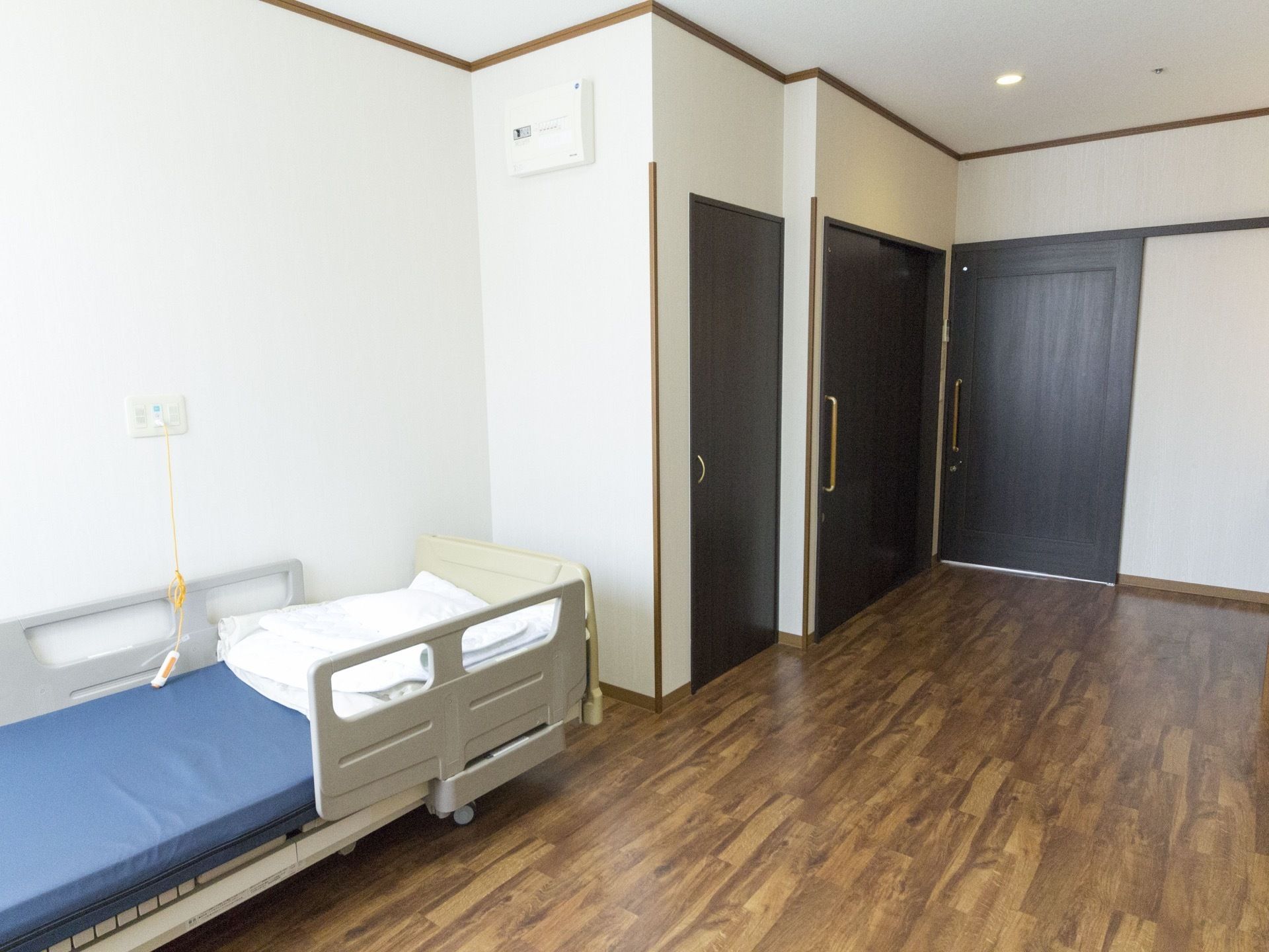 居室の扉は、足に不自由のある入居者様も利用しやすい引き戸になっている。手前に介護用ベッドが設置してある。