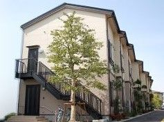 1階はタイル張り風、2階はアイボリーに切り替えられた外壁で、切妻屋根の2階建ての建物