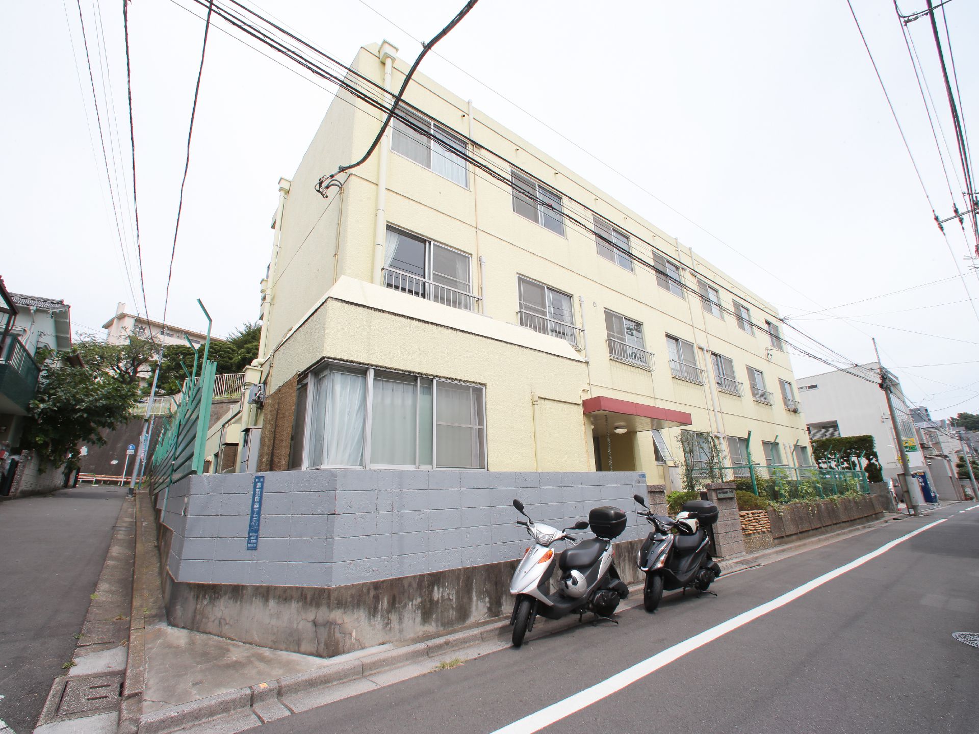白で統一された清潔感のある3階建ての建物。角地にあるので、車での来所が便利で、日当たりがよく環境に良い。