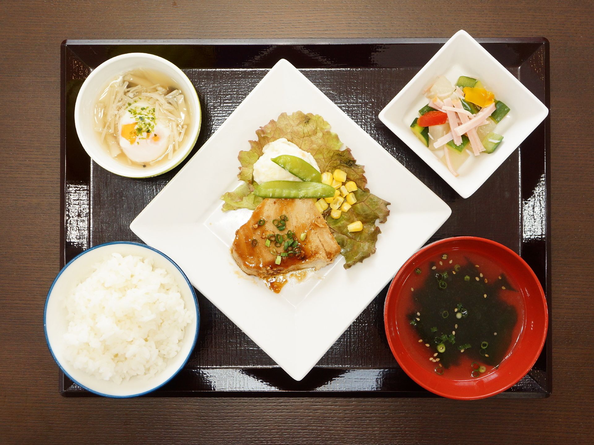 食事は一人一人お盆の上にのせられて配膳される。真ん中にメインのおかず、それを囲むように小鉢やお吸い物、ご飯などが置かれている。