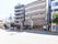 建物の一階の左側に整形外科があり、右側が施設の入り口である。両隣にも同じくらいの高さの建物が建っている。