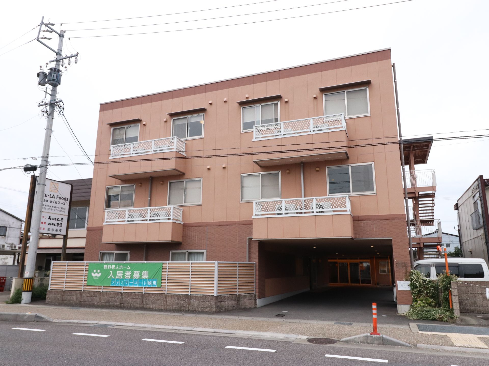 建物の一階の右半分はピロティとなっており、その外側の壁に非常階段がある。三階建てで2、3階には同じように窓が付いている。