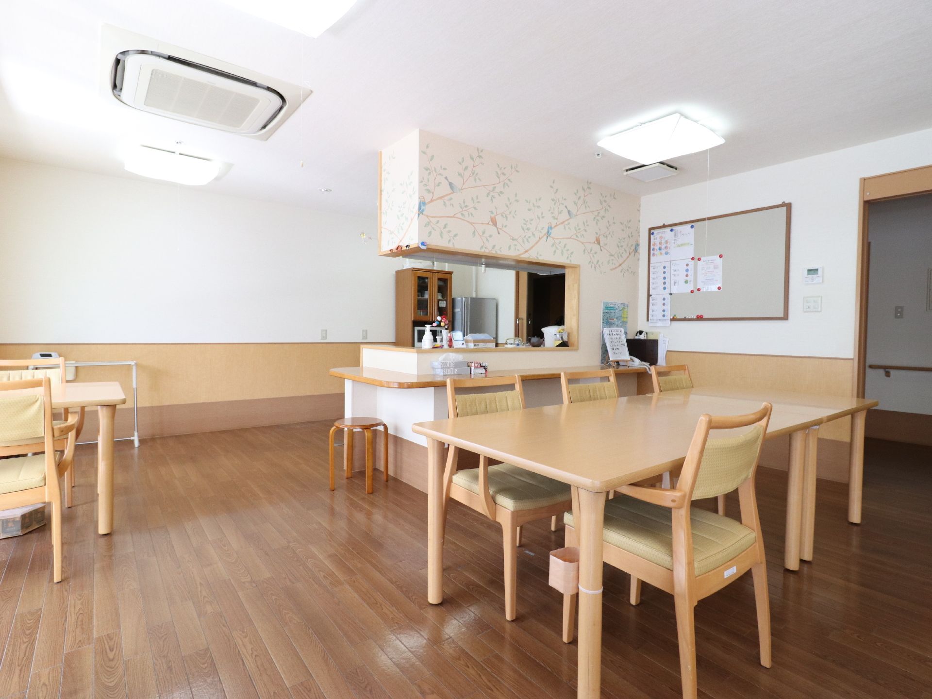 ダイニングルームは、食事をする他に入居者様達の憩いの場にもなっている。ベージュ色のダイニングテーブルが置かれている。