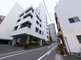 白い車が停まる市街の駐車場