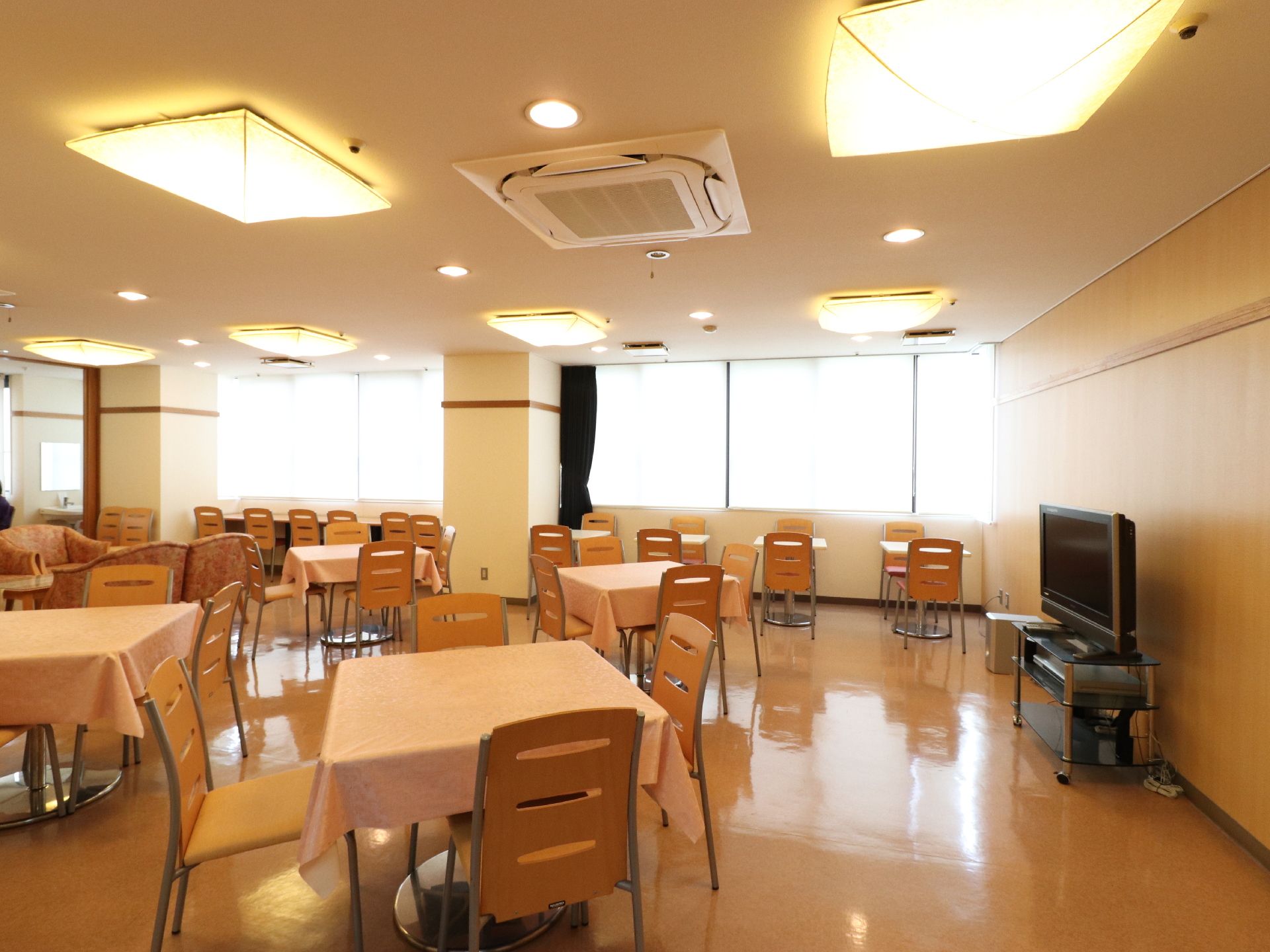 ダイニングには4人掛け、2人掛けのテーブル席と、ソファー席、窓際にはカウンター席も用意されている。大型テレビが設置されている。