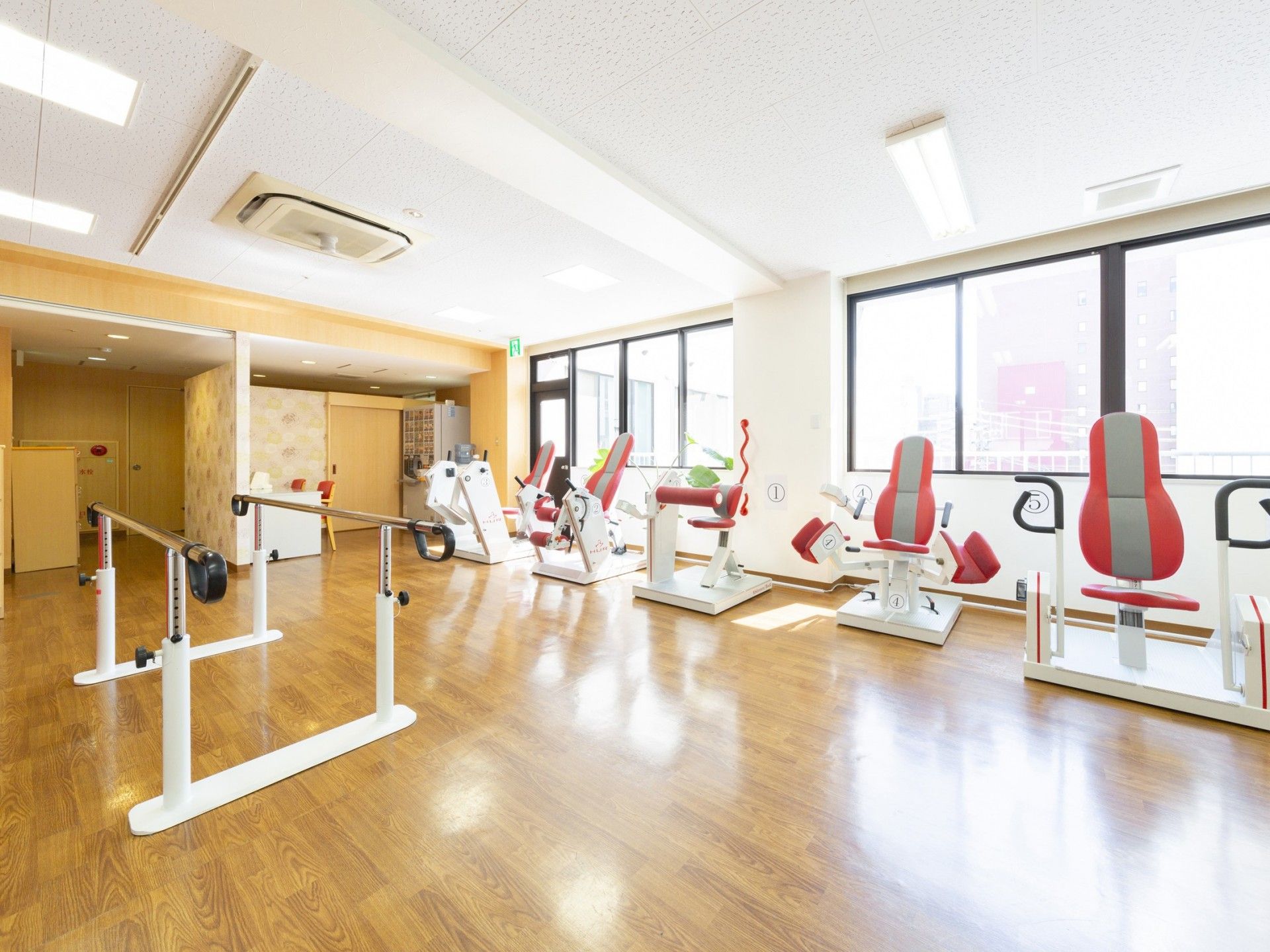 左正面に格子の3連扉の仕切り、右に窓がある、クロスのかかったテーブルが並べられた食堂