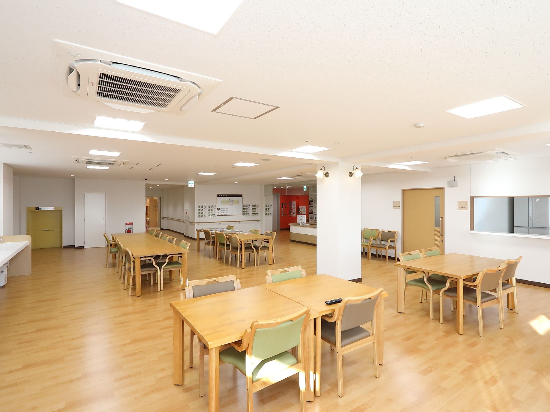 4人掛けテーブルと、複数人が座れる席が設けられている食堂である。広く開放感があり、明るい室内である。