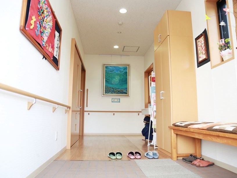 入り口正面には絵画が飾られている。フリーペーパーやチラシが棚に置かれており、手前にはクローゼットが設置されている。