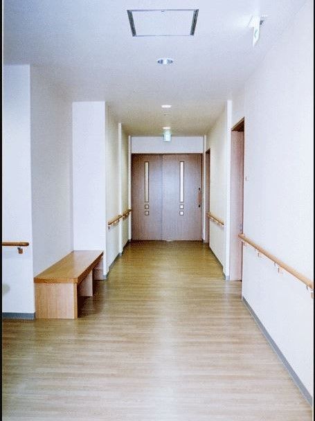 施設内の廊下は広く、壁に沿って握りやすい高さの手すりが設置されている。休憩したいときには、横長の木製ベンチがある。