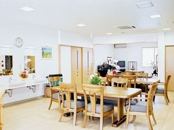 白い内装、クリーム色の床、左壁面に2つの洗面台のある食堂