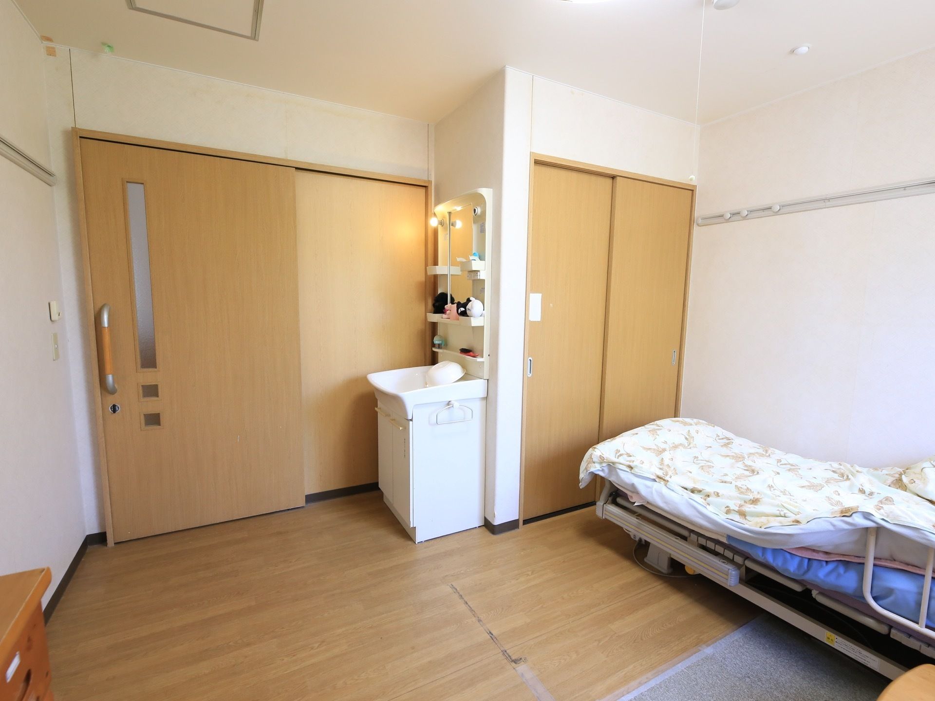 曇りガラスの窓が開いた入口扉が左奥にある。ドアの前に洗面台があり、その隣に収納スペースが用意されている。