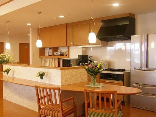 Ⅱ型キッチンになっており、対面側にはカウンターが設けられている。背面にあるガス台の並びには大型冷蔵庫が置かれている。