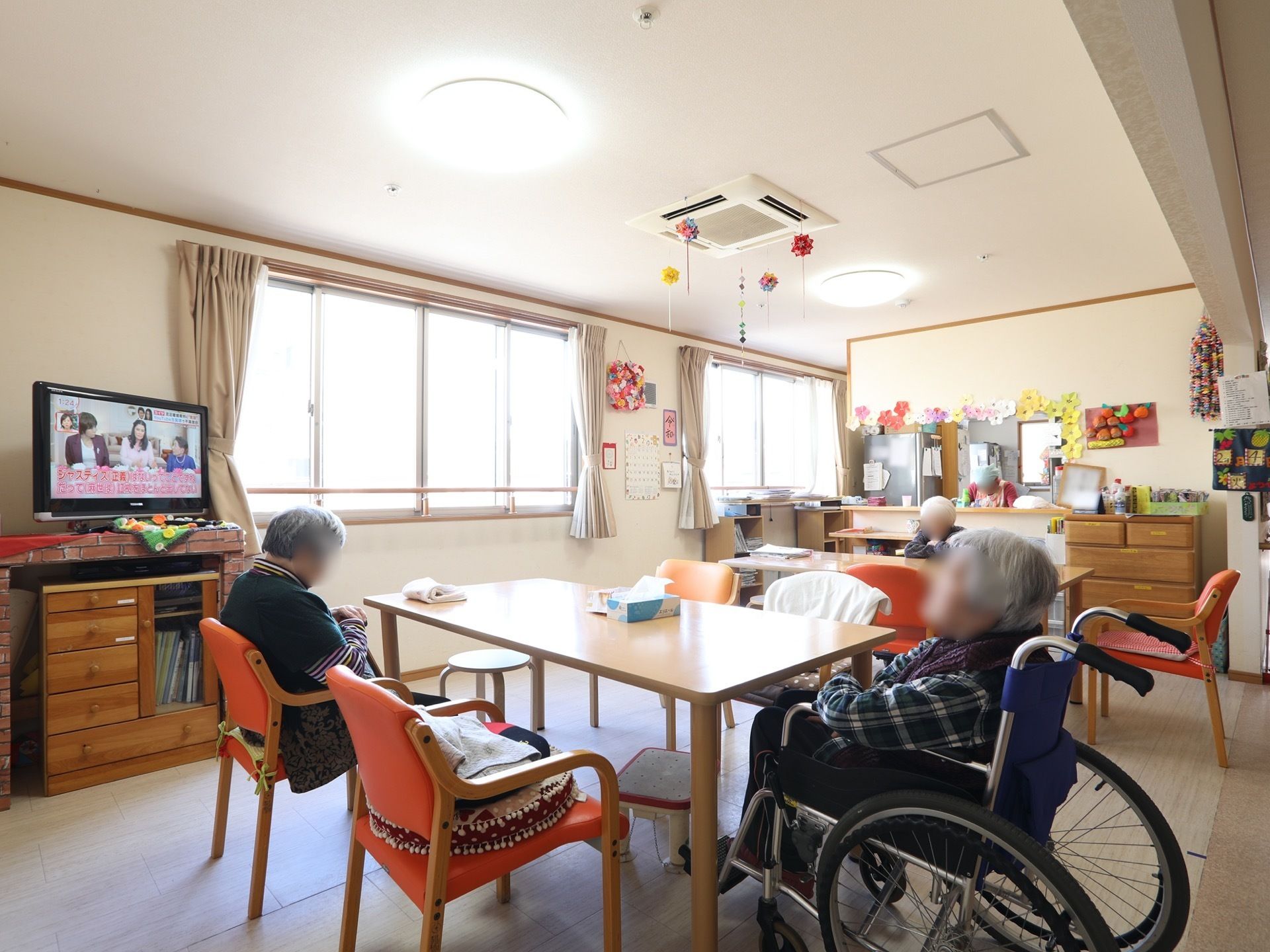 テレビがある共有スペースには、手作りのデコレーションが天井や壁に貼られている。大きな窓が２か所あり明るい。