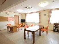 床はベージュのクッションフロア貼りで、窓から光が入り明るい。ダイニングセットが間を空けて並んでいる。