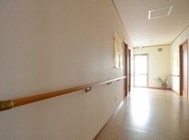 正面に窓があり光が入っている。壁にはところどころに扉があり、壁には丸い握りの手すりが付き、掲示物も貼られている。