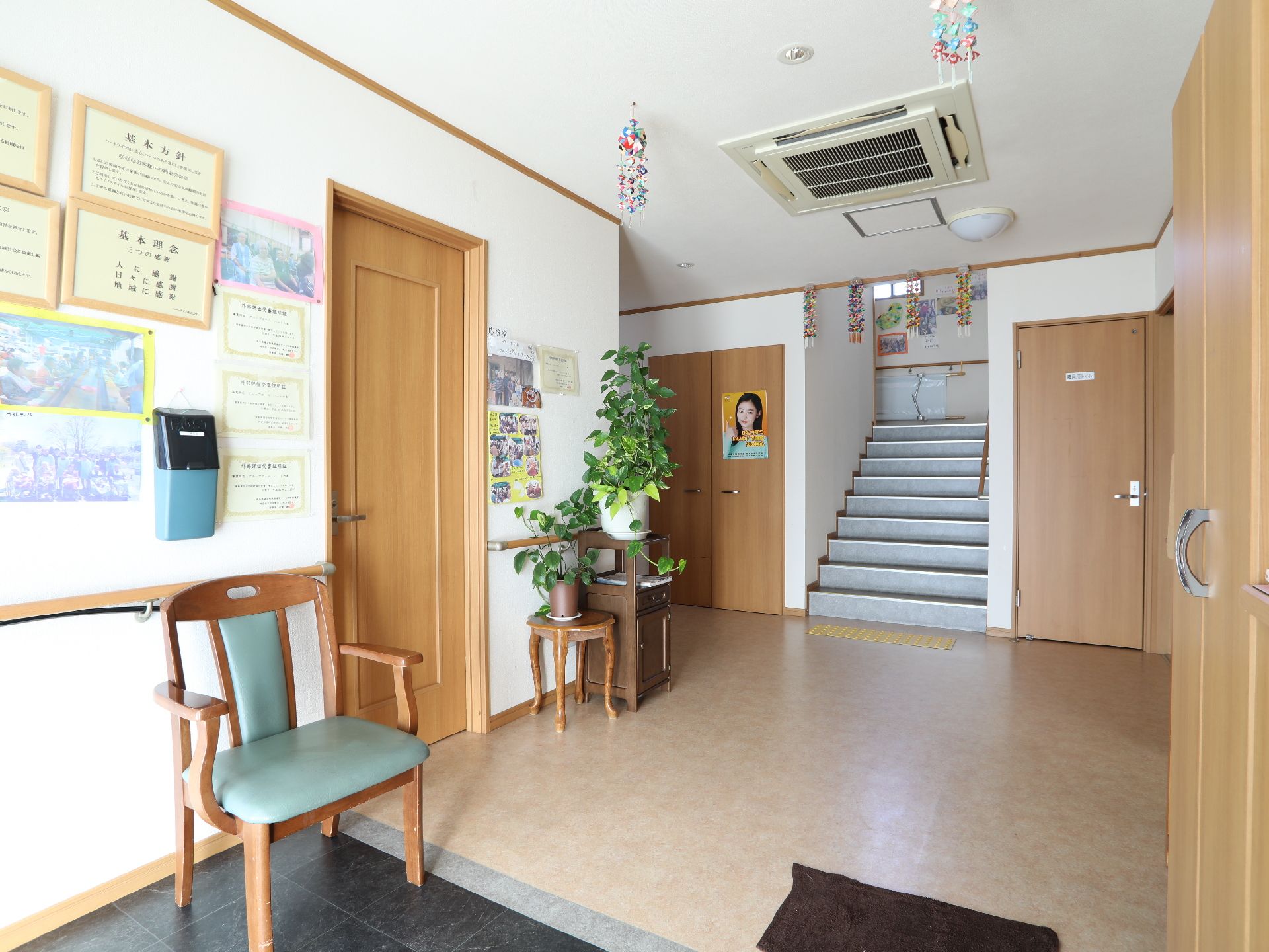 左手前に黒い三和土があり段差なくクリーム色の床に続いているホール