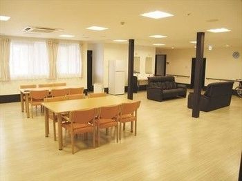 黒いソファーと木製のテーブルセットが配置された共有スペース。