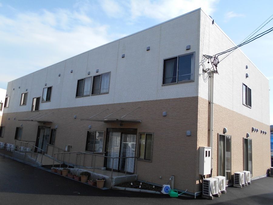 白と茶色のツートンカラーの建物。高齢者施設の外観。