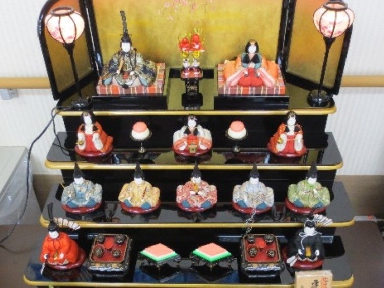 4段の雛飾り。雛人形と菱餅が飾られている。