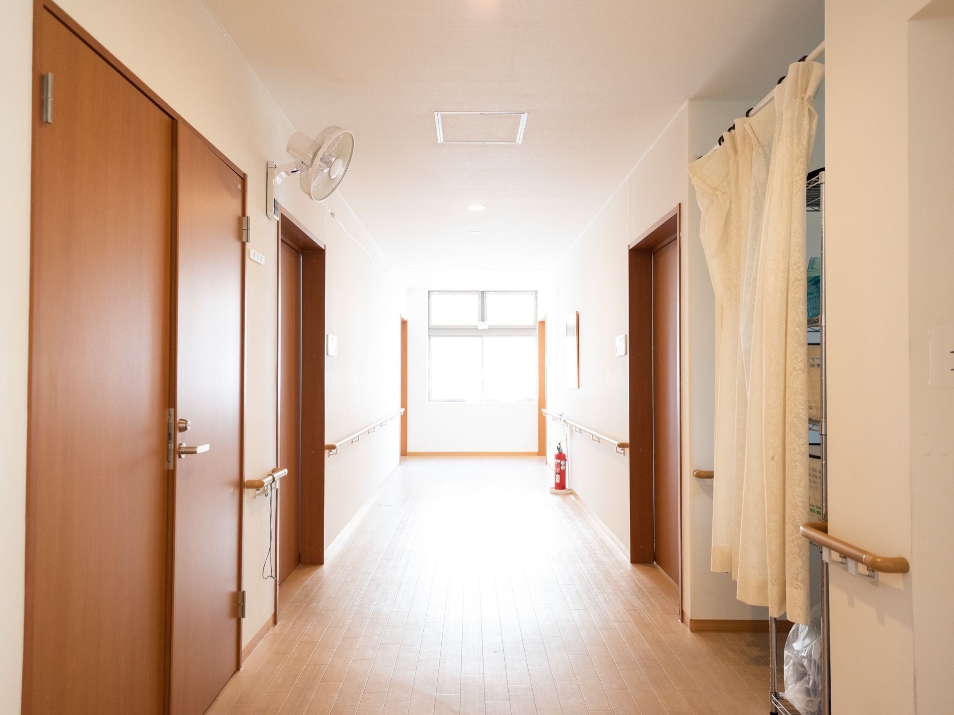 広い廊下は、すっきりとしていて、余計なものが置いてない。カーテンで仕切られた収納スペースがある。消火器が床に置かれている。