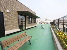 緑色の床が心地よい屋上では、ベンチに座って花壇の花々を眺めたり、日光浴をしたり、のんびりと過ごすことができる。