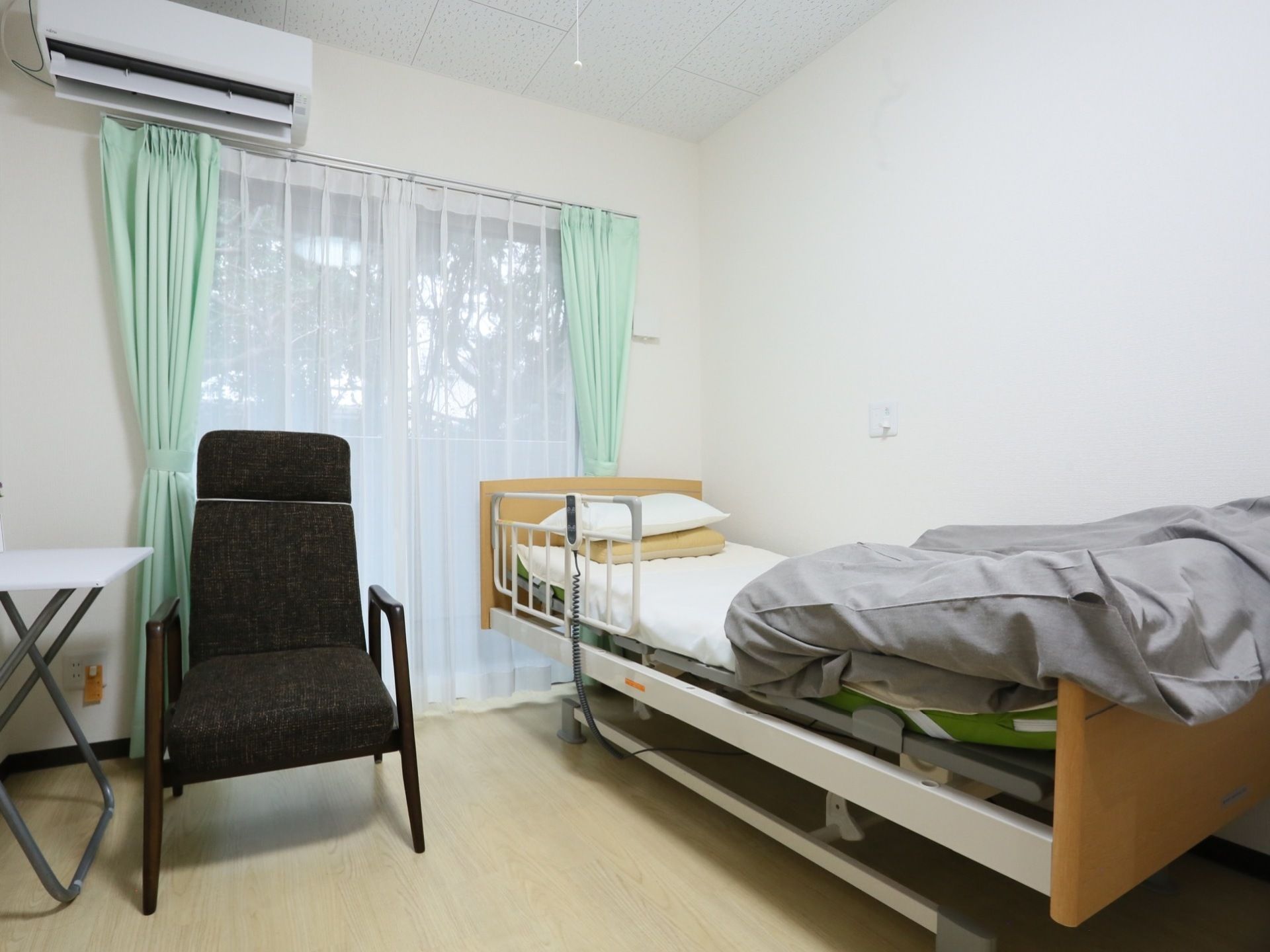 ベランダに続く大きな窓辺にベッドが設置されている。傍らには呼び出しボタンがあり、緊急時にスタッフにすぐ連絡できるようになっている。