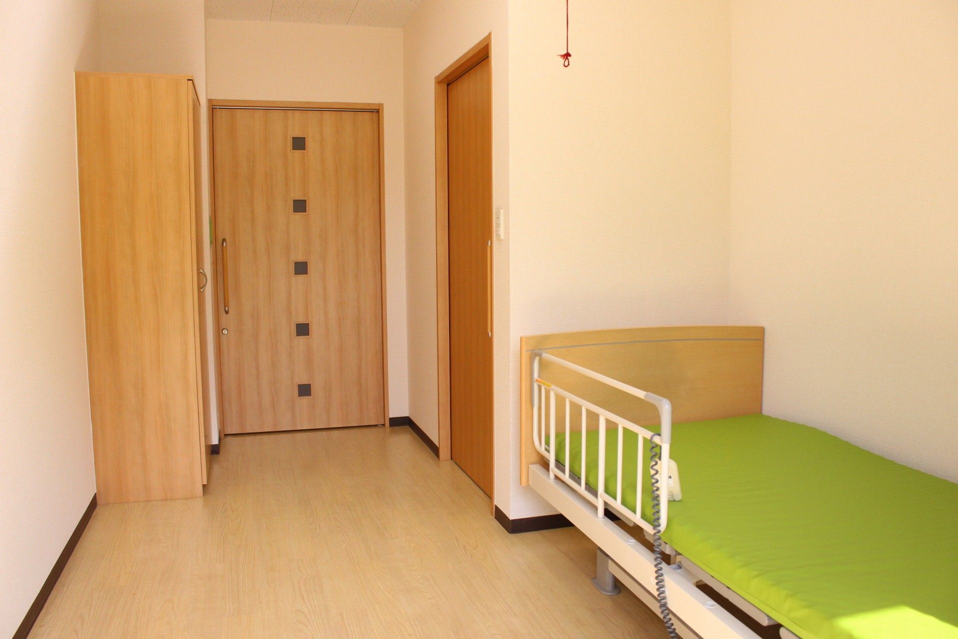 正面に窓が2つ、フローリングで右側に木目調の開き戸がある個室