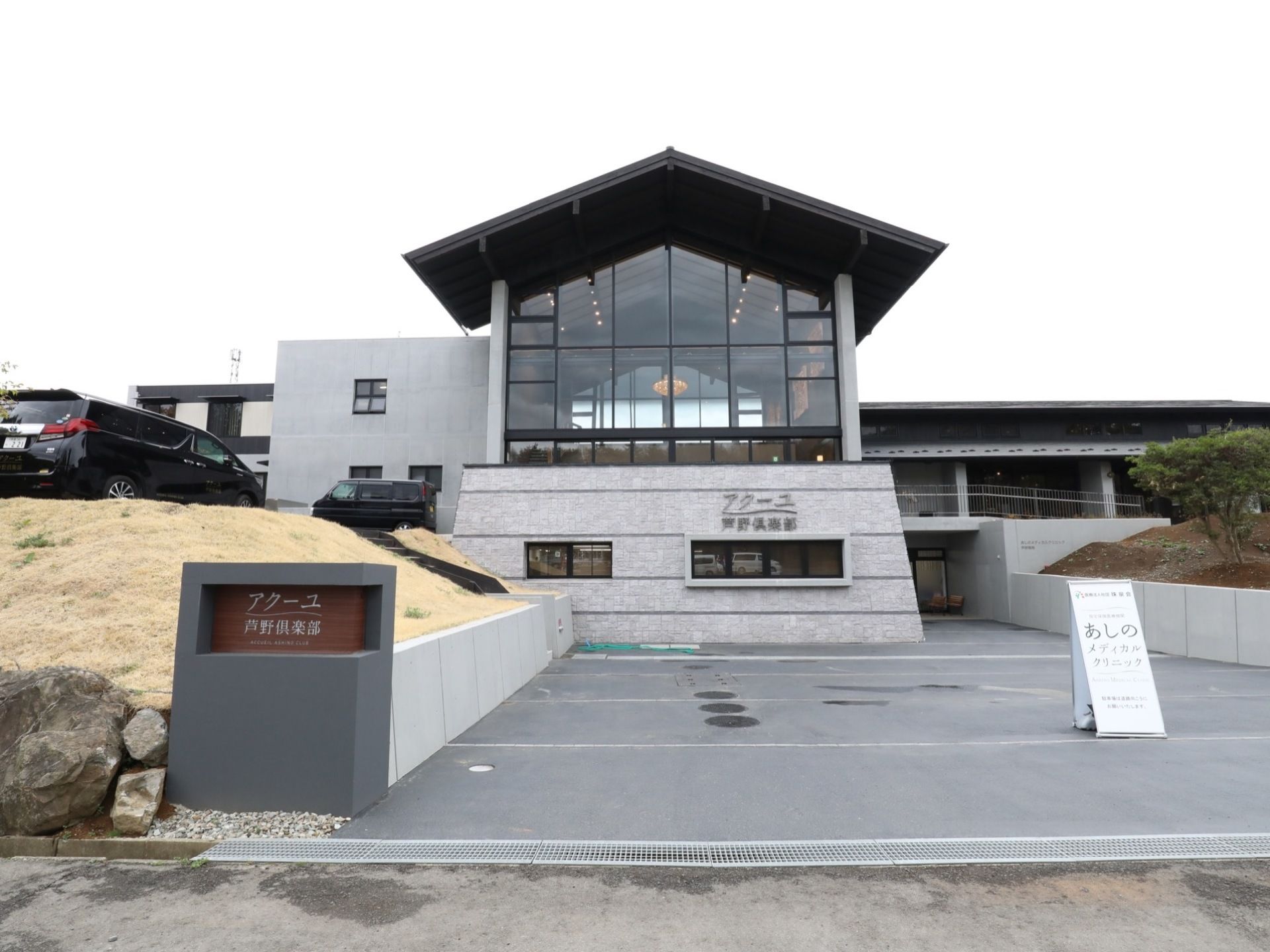 建物の窓ガラスが印象的で、中のシャンデリアが見えている。敷地内はきれいに整備されていて、路面も舗装されている。
