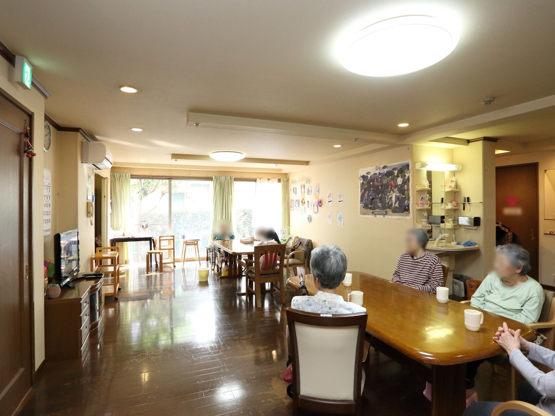 広々とした明るい談話室には、大型液晶テレビや大人数で座れるダイニングテーブル、洗面所が完備されている。