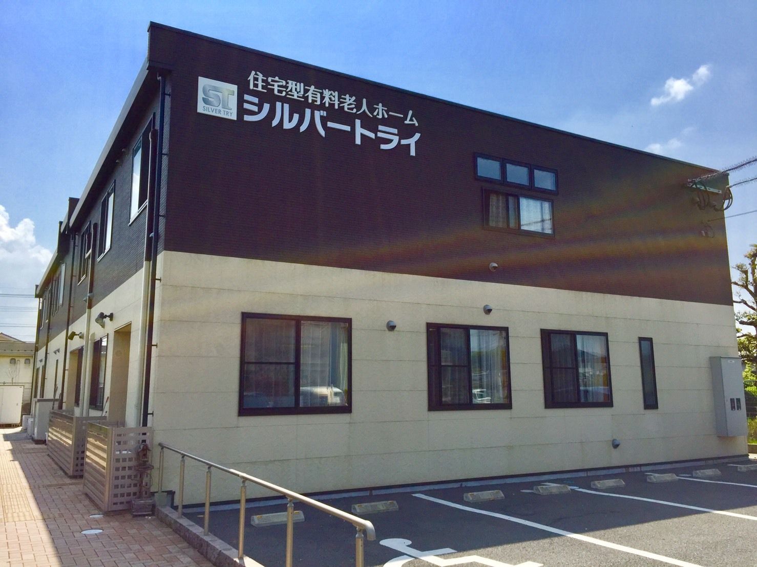 シルバートライ朝倉の外観。茶色と暖色がシックにオシャレな洋風モダンテイストの施設外観です。