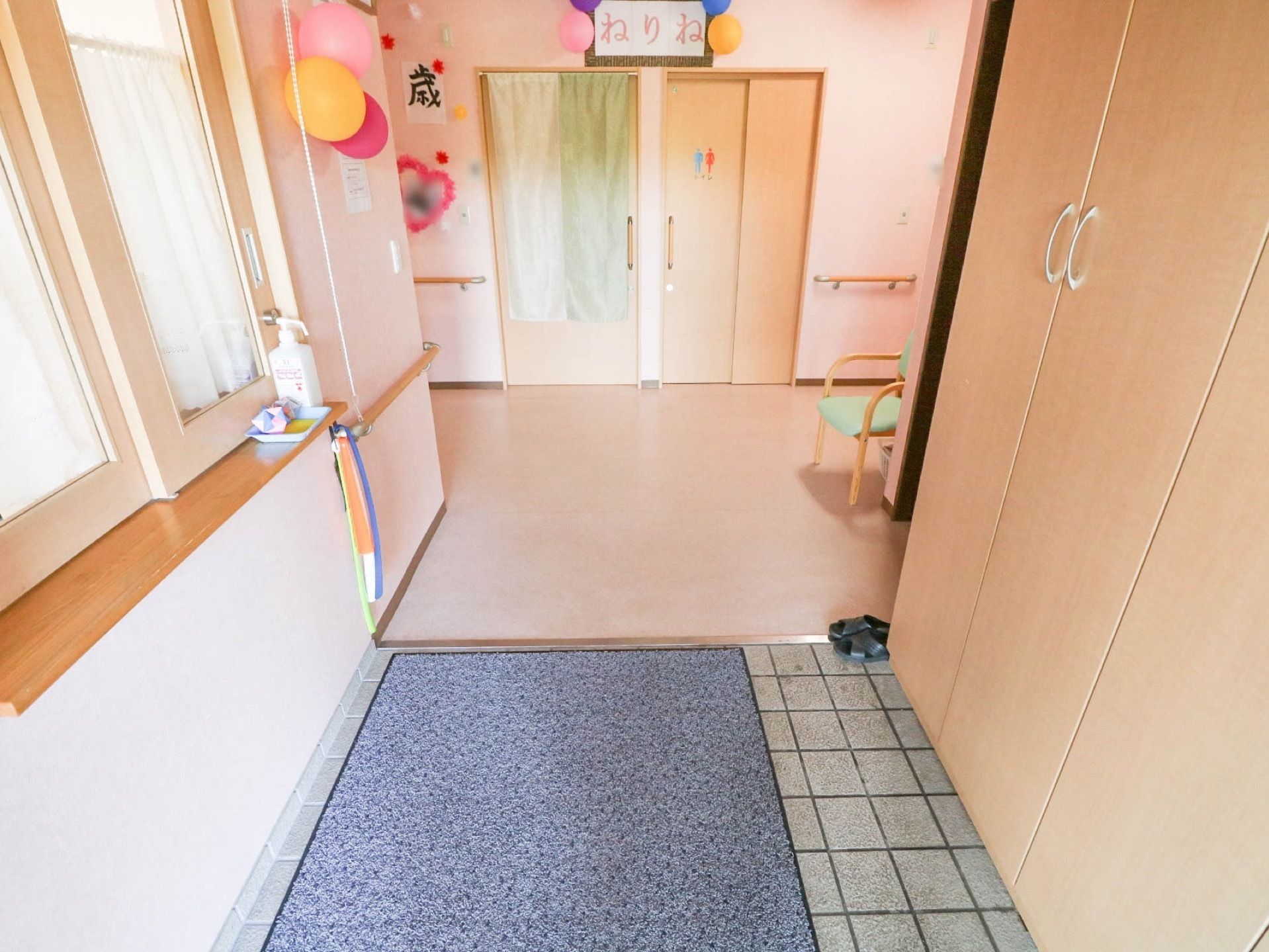 エントランスには、扉付きの大きな木製の靴箱が設置されている。横には、ひじ掛け付きの椅子が用意されている。