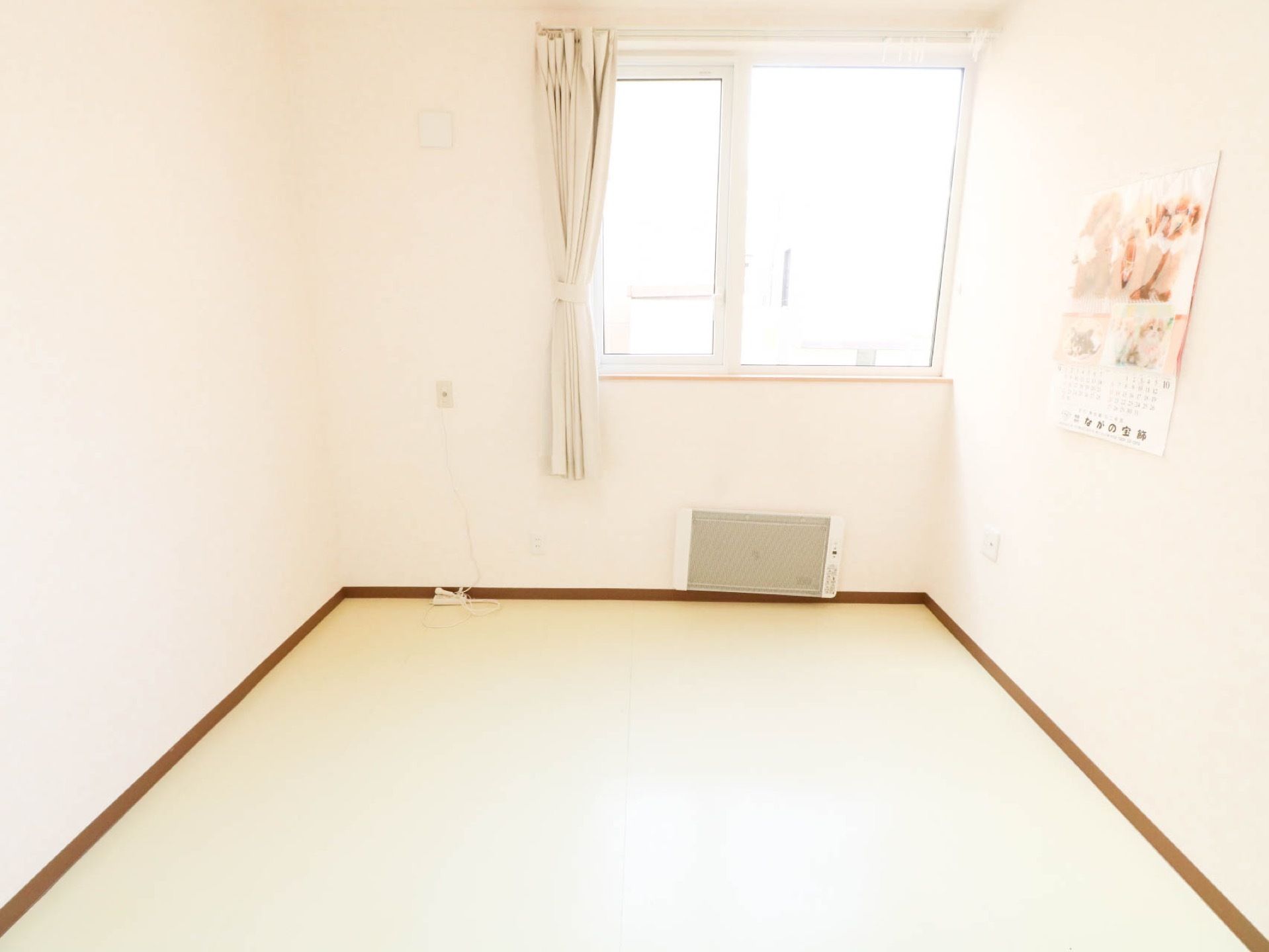 長方形型のシンプルな居室である。窓が設けられているので明るく、壁にはナースコールや暖房が設置されている。