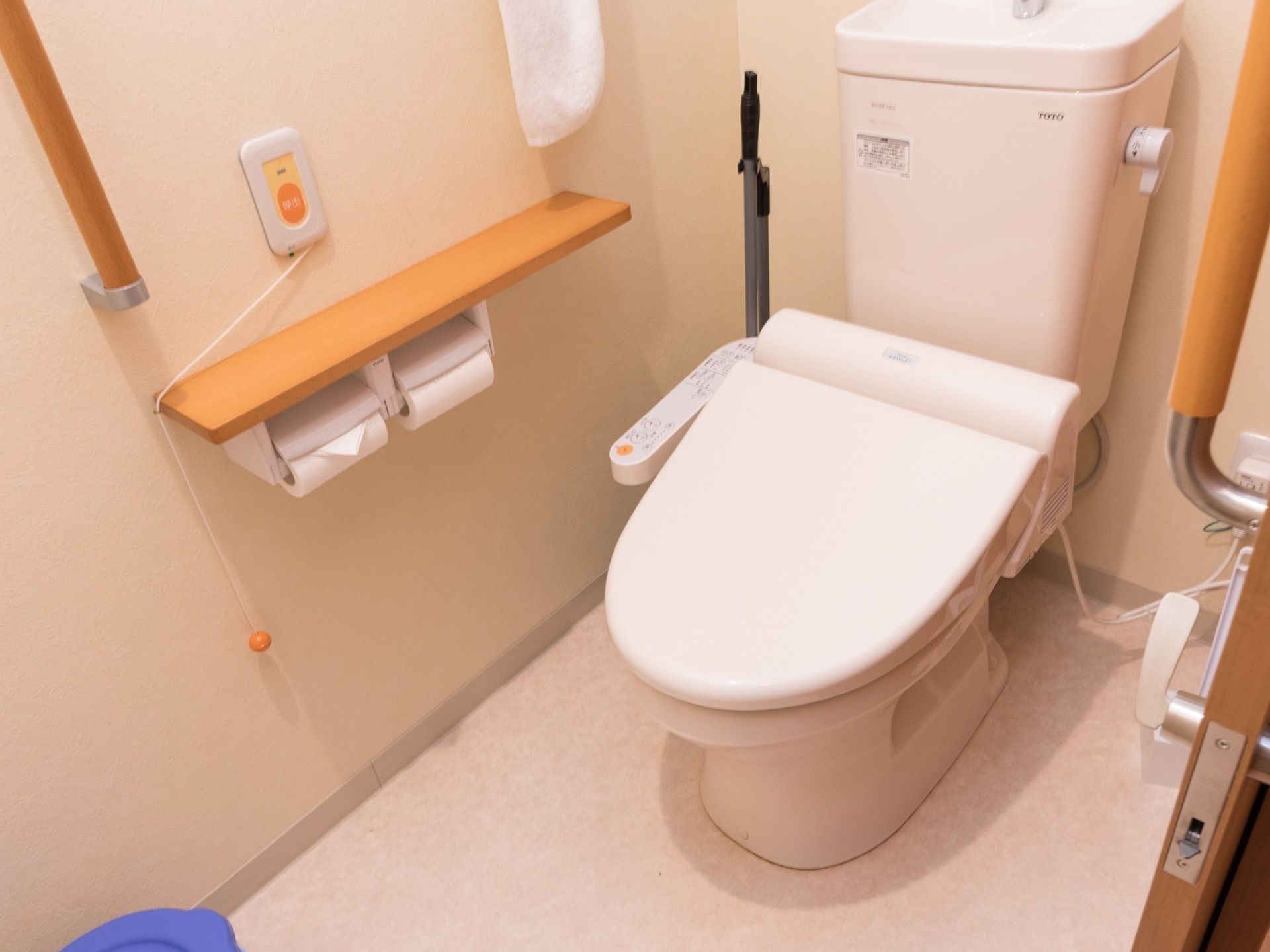 トイレには洋式便器が設置されている。トイレットペーパーフォルダーが2つ並んだ上には呼び出しボタンが設置されている。