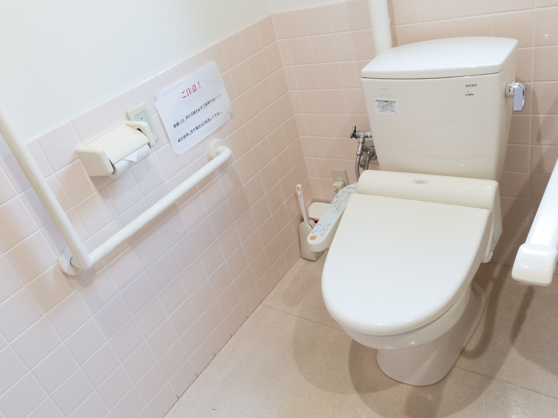 明るい内装で居心地の良い個室には、温水洗浄便座が設置されている。便器のそばには手すりや安全バーが設置されているので安心して利用できる。
