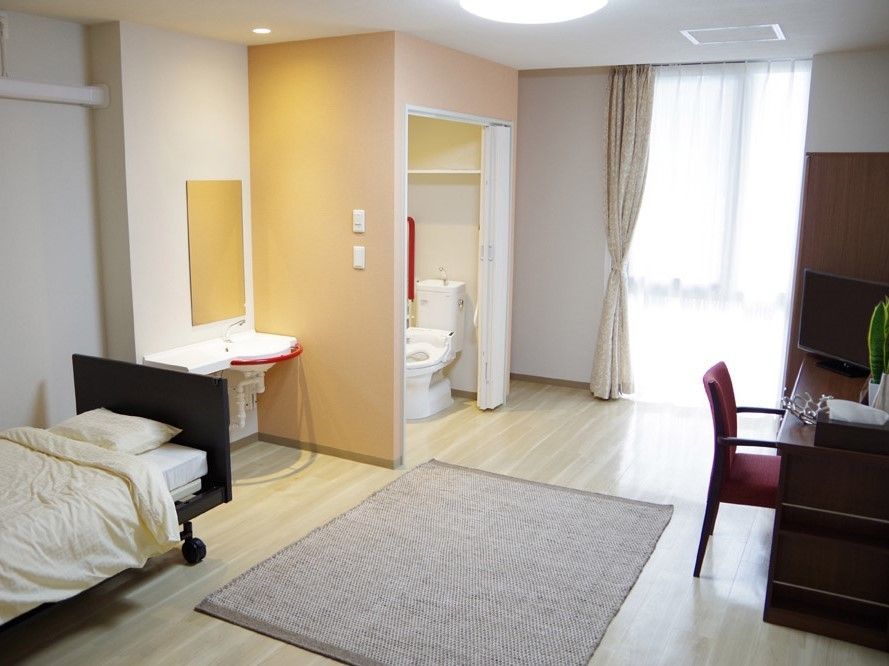 アコーディオンドアで区切られたトイレと、洗面台が室内に設置されている居室