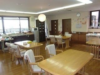 大きな採光の窓があり、四人掛けテーブルが並ぶ食事スペース