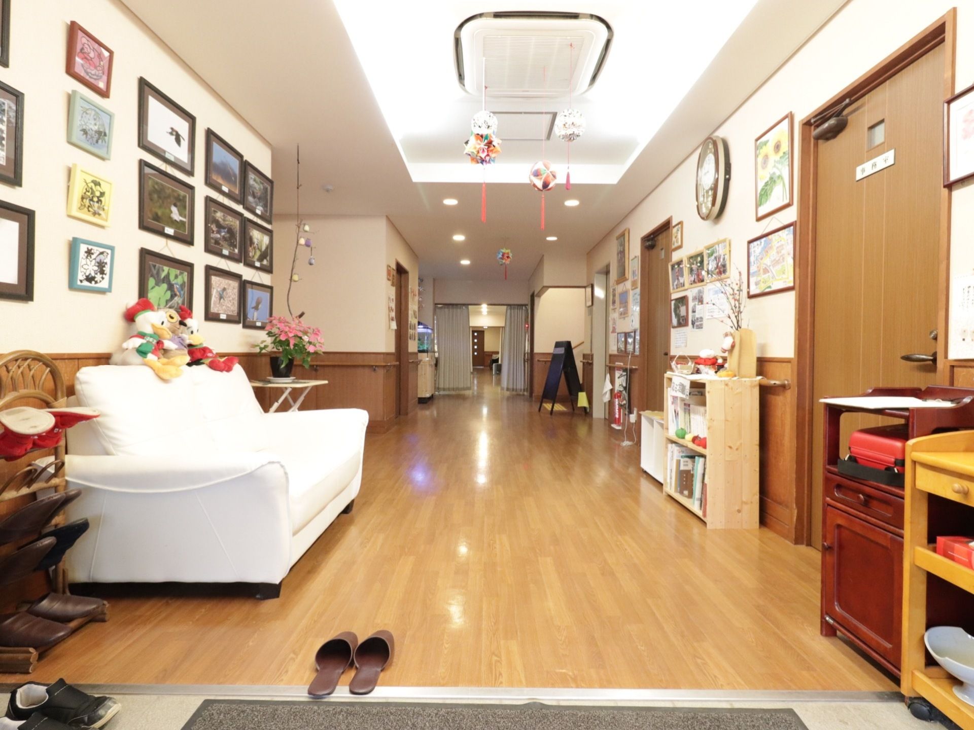 ホールにはさまざまな作品や写真が飾られている。ホールに面した位置に事務所がある。スタッフが24時間体制でサポートに当たっている。