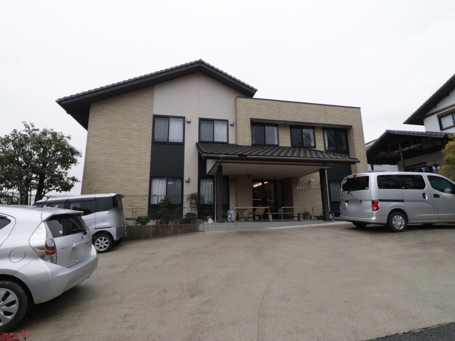 和風な印象の２階建て。広めの駐車場が完備されている。駐車場から玄関まで緩やかな傾斜がついている。段差がなく安全に移動ができる。