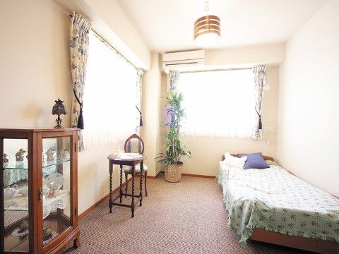 猫足の椅子、花柄のベッドカバー、カップボード、グリーンのある個室