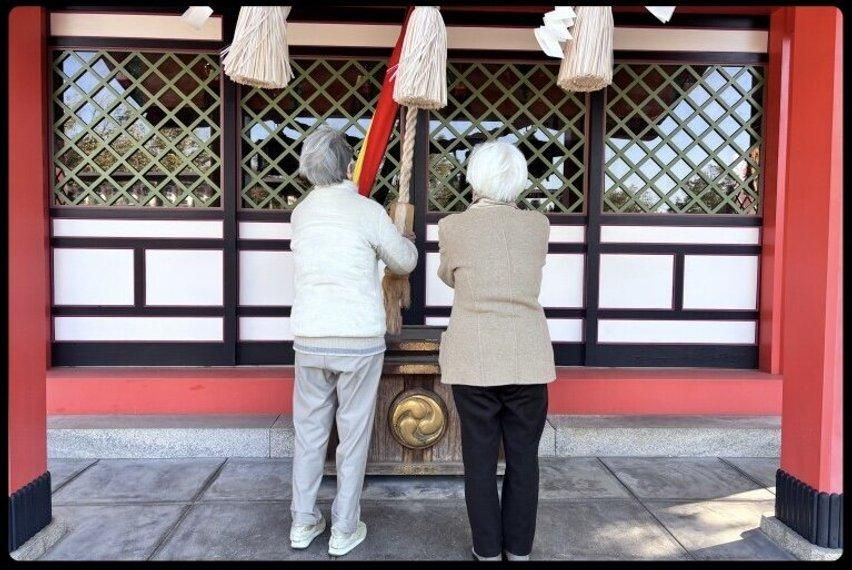 神社で祈る二人