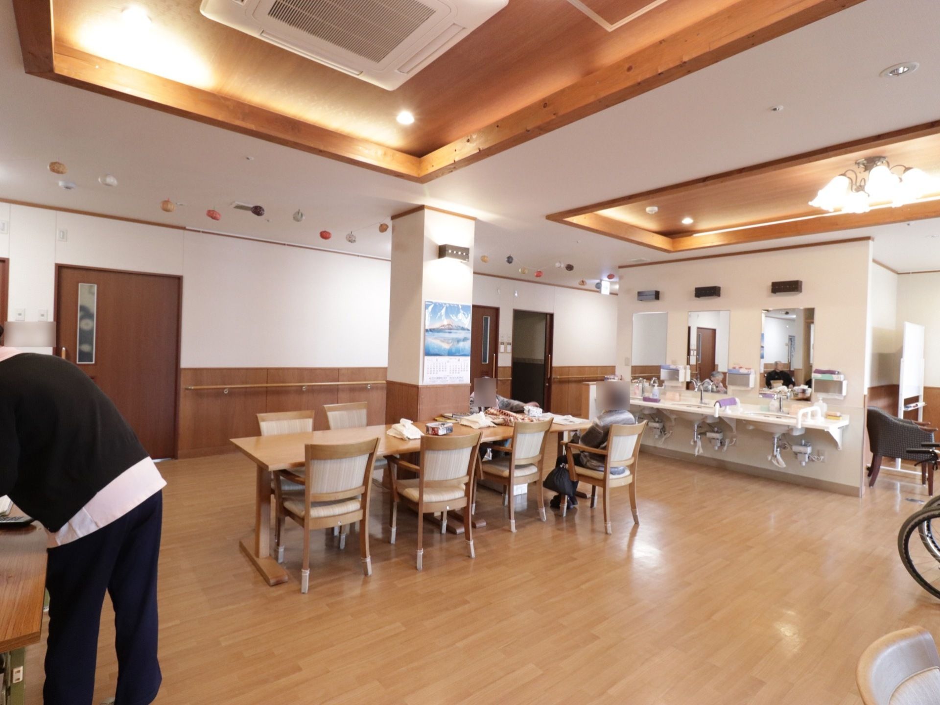 食堂は広々として開放的である。手すり付きの洗面台が設置されている。天井にビルトインのエアコンが装備されている。