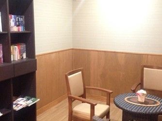 小さな丸テーブルを囲むチェアと本棚のあるフリースペース