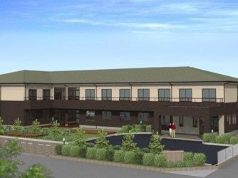 低木や芝生に囲まれた緑色の屋根の２階建て建物の外観イメージイラスト