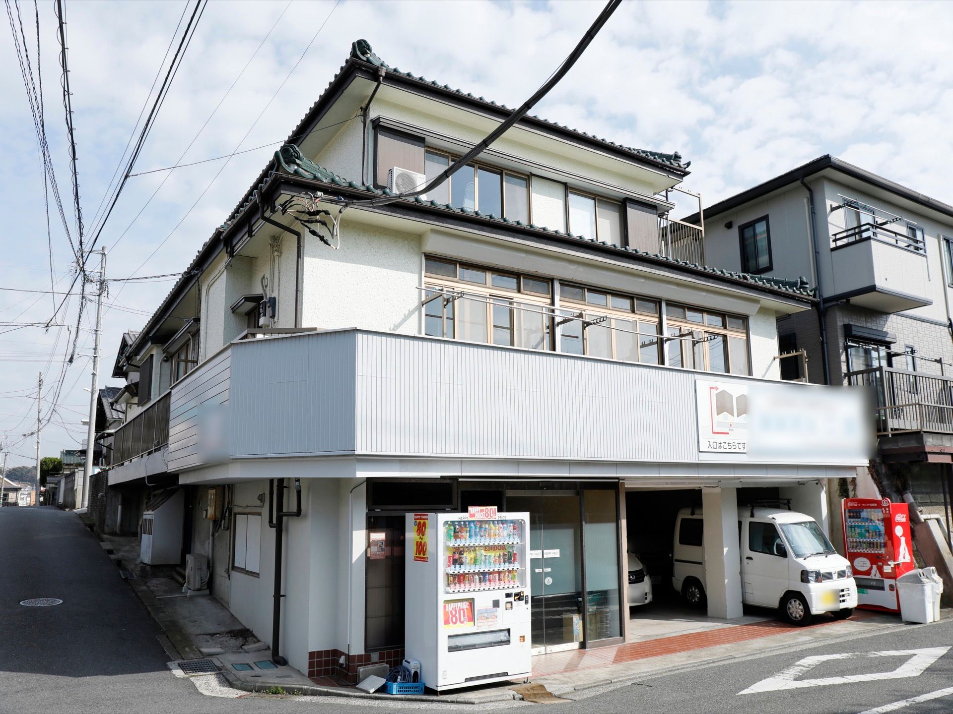 住宅街に施設が立地している。１階に自動販売機が２機設置されているので、好きな飲み物を購入することができる。