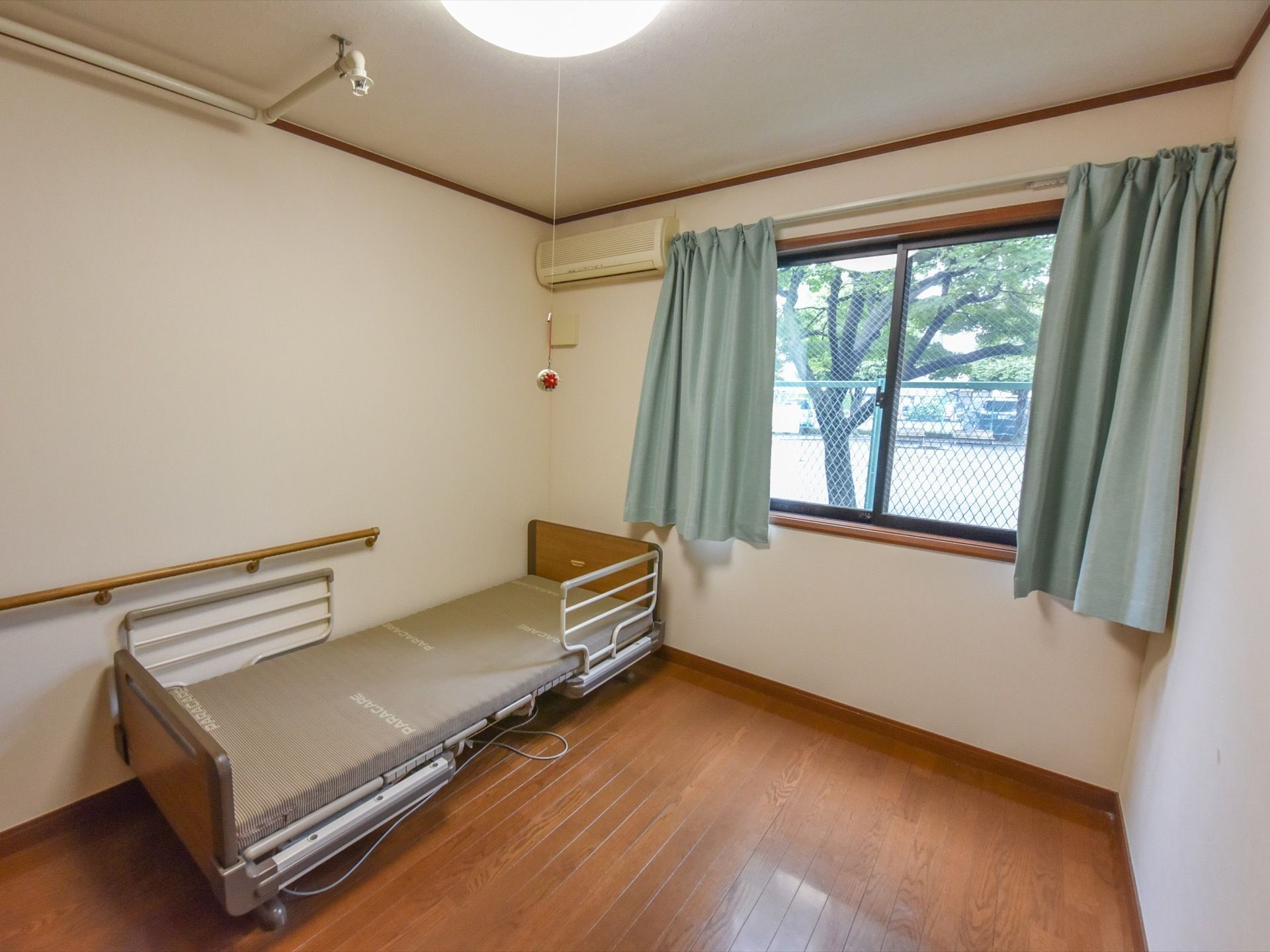 居室には、大きな窓があり、外の光が差し込み、又外の景色が見える。広い部屋に電動式のベッドが置かれている。